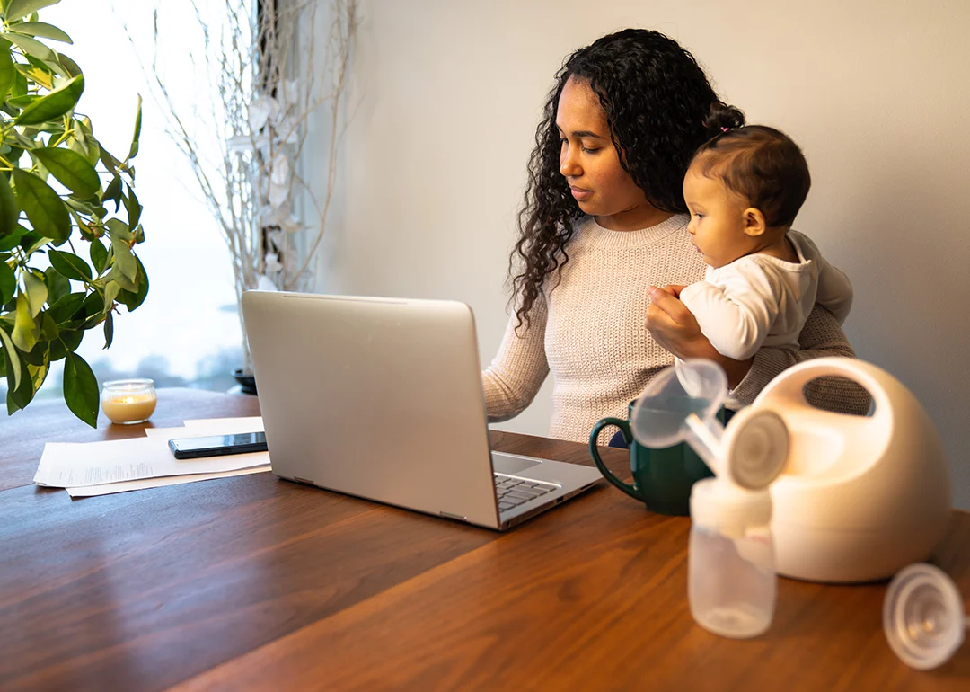 Mom holding baby near computer